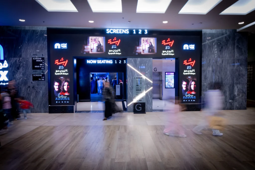 Motion blur of guests walking past the VOX Cinema entrance during the Rabsha film premiere night in Jeddah.
