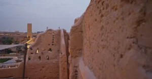 Historic mud-brick walls of At-Turaif in Diriyah, Saudi Arabia, illuminated by warm evening light