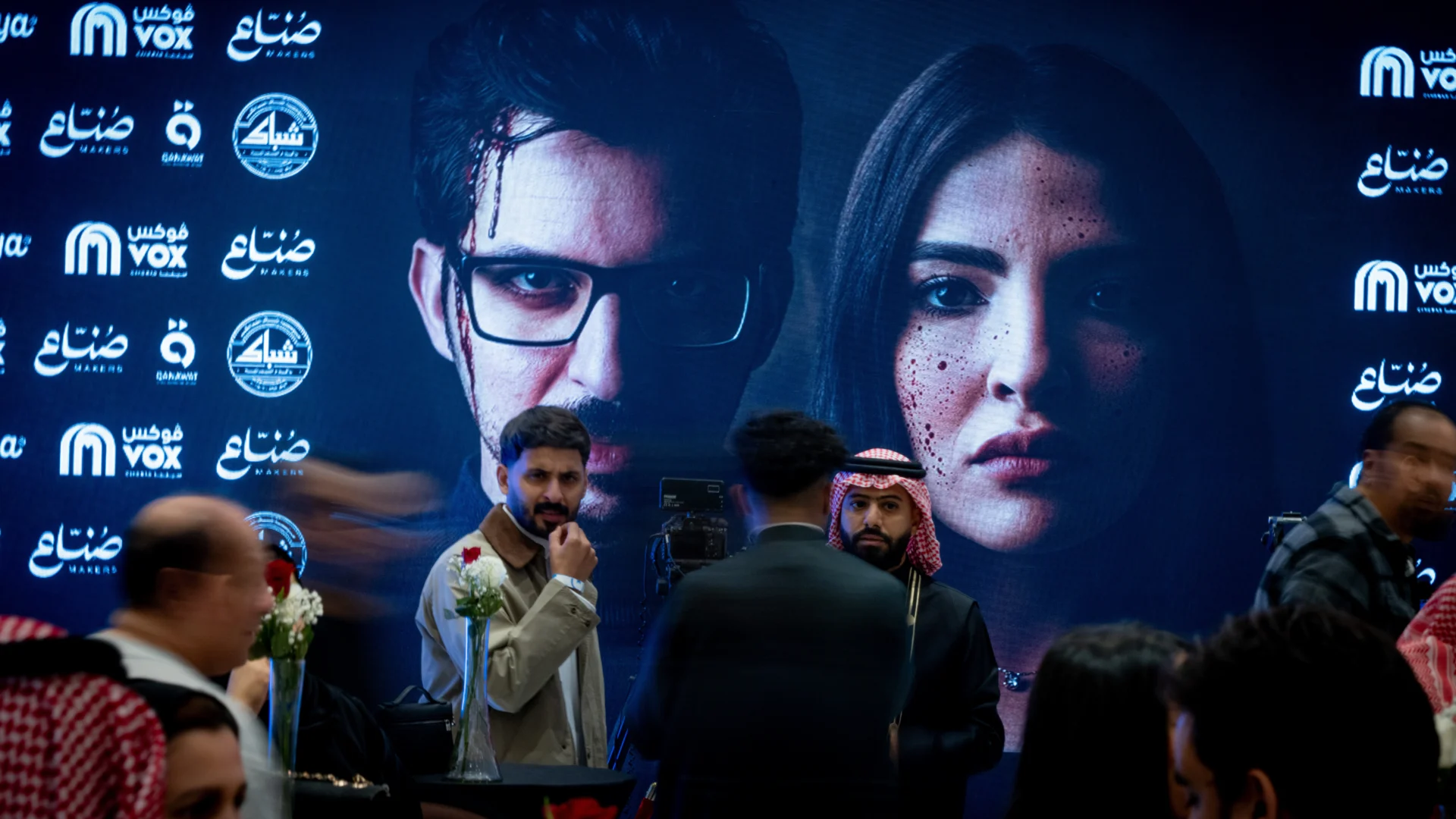 Guests posing in front of the official Rabsha movie poster backdrop during the premiere night event coverage at Muvi Cinemas.