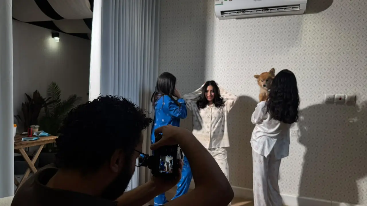 Photographer capturing a pajama product shoot with models indoors