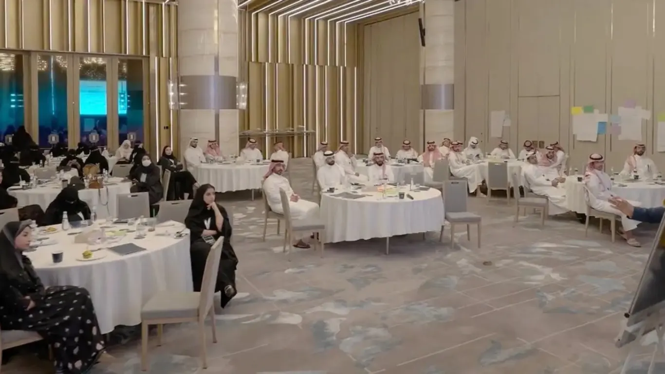 Corporate event coverage of the Ministry of Health gathering in a Riyadh conference hall, featuring round tables, seating configurations, and formal networking spaces