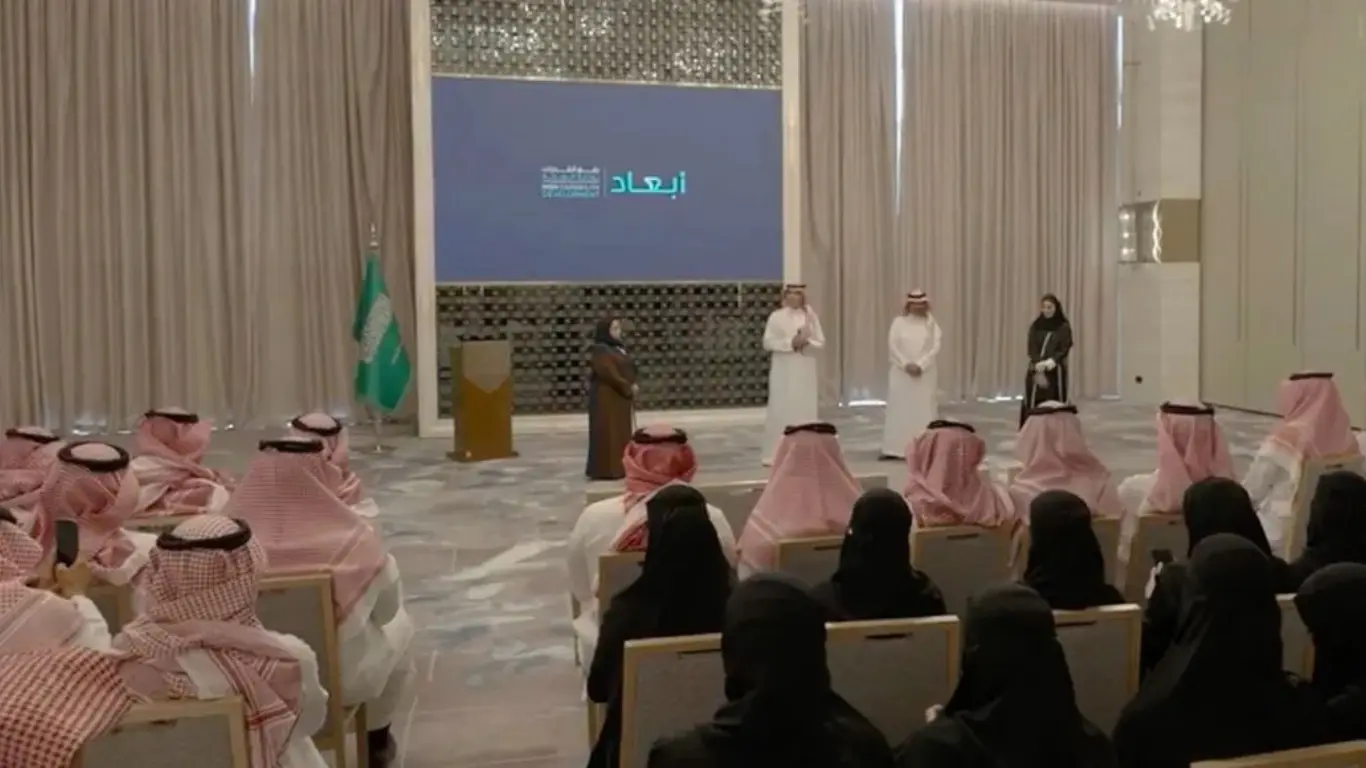 On-stage multimedia display during the Ministry of Health event coverage in Riyadh, showing attendees watching an active corporate interview presentation.